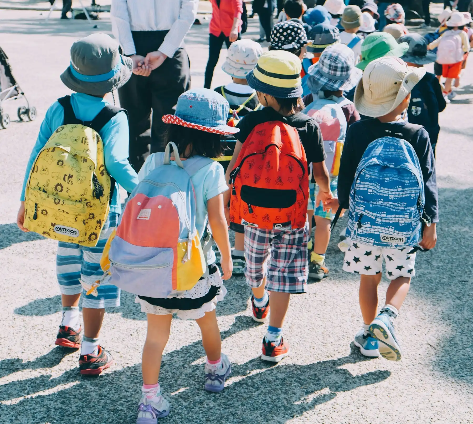 Crianças com mochilas caminhando para a escola